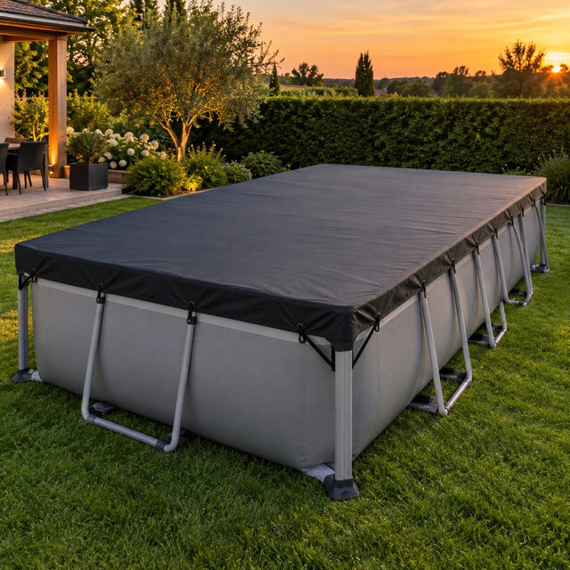 Piscine rectangulaire hors sol entièrement recouverte d'une bâche sombre bien tendue, sandows accrochés aux montants d'angle