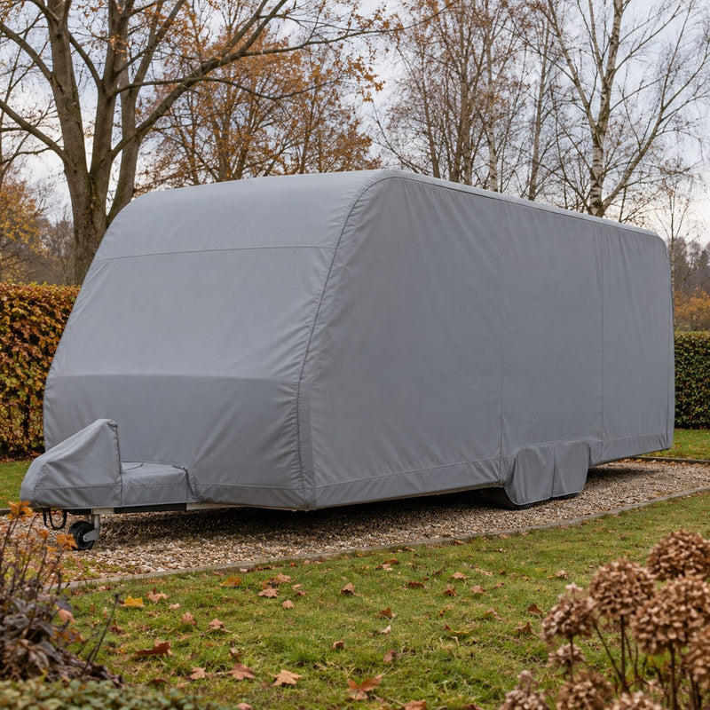 Caravane couverte d'une housse grise bien tendue dans un jardin en fin d'automne